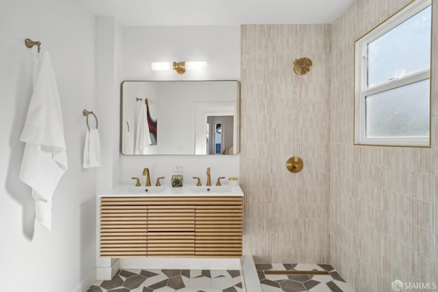 bathroom featuring tiled shower and vanity