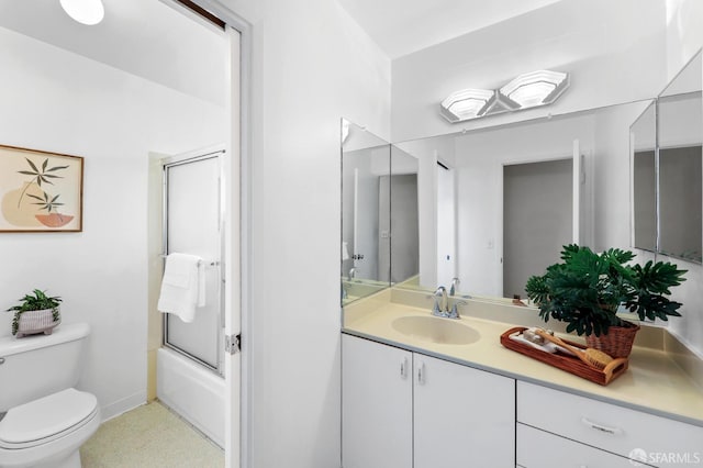 bathroom with toilet, baseboards, shower / bath combination with glass door, and vanity