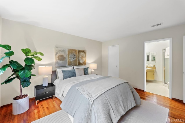 bedroom featuring visible vents and wood finished floors