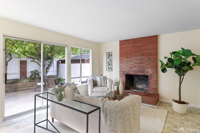 living area featuring a brick fireplace and baseboards