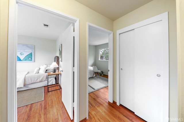 hall featuring visible vents and light wood-type flooring