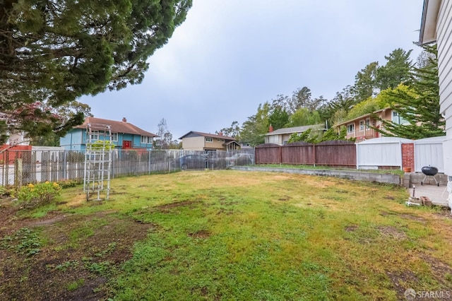 view of yard with a fenced backyard and a residential view