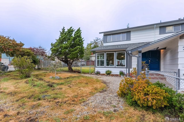 exterior space featuring roof with shingles and fence