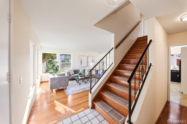 staircase with baseboards and wood finished floors