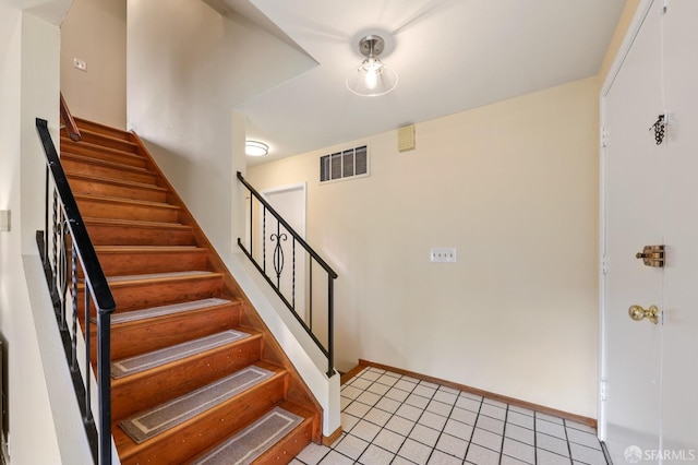 stairs featuring tile patterned floors, visible vents, and baseboards