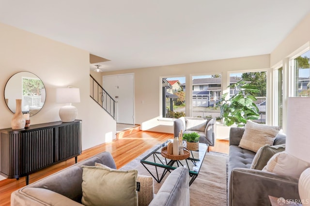 living room featuring stairs and light wood-style flooring