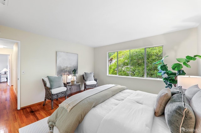 bedroom with baseboards and wood finished floors