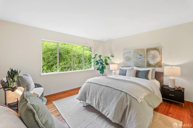 bedroom featuring baseboards and wood finished floors