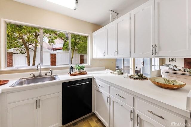 kitchen featuring a sink, light countertops, white cabinets, and black dishwasher