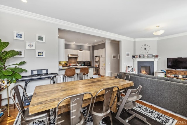 dining space featuring hardwood / wood-style floors and crown molding