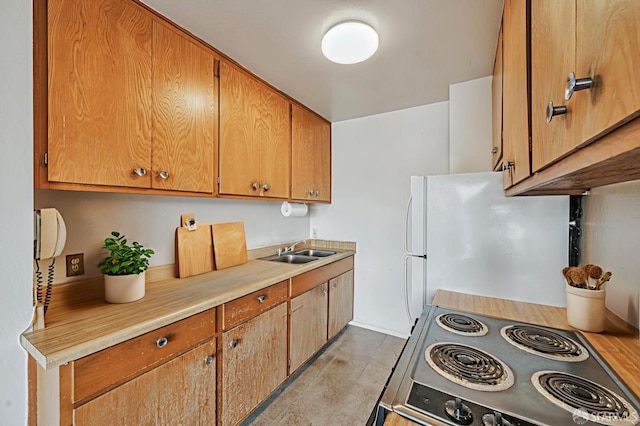 1455 Laguna St Unit 6, San Francisco, CA 94115 - kitchen featuring range, freestanding refrigerator, a sink, light countertops, and brown cabinets