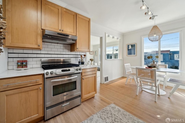 kitchen featuring under cabinet range hood, visible vents, light countertops, and stainless steel range with gas stovetop