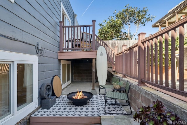 view of patio featuring an outdoor fire pit and fence