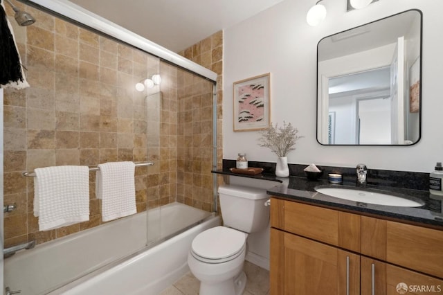 bathroom with toilet, tile patterned flooring, enclosed tub / shower combo, and vanity