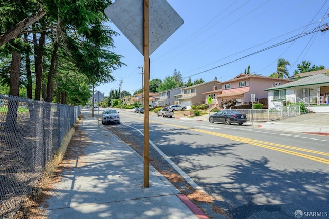 19652 Stanton Ave, Castro Valley, CA 94546 - view of asphalt road with sidewalks, a residential view, curbs, and traffic signs