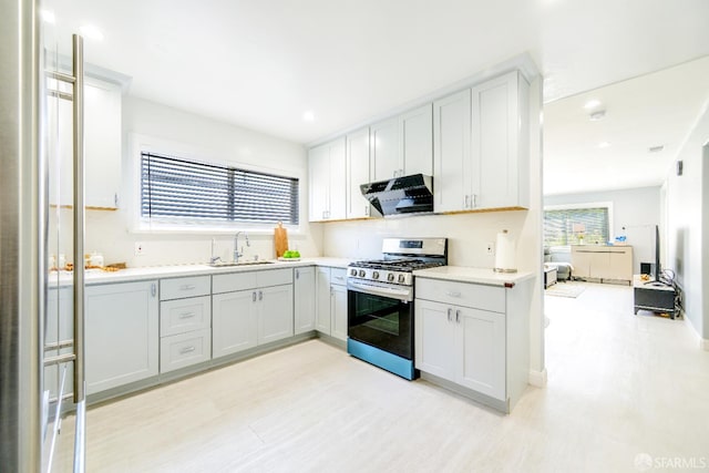 19652 Stanton Ave, Castro Valley, CA 94546 - kitchen with stainless steel range with gas cooktop, range hood, light wood-style floors, light countertops, and recessed lighting