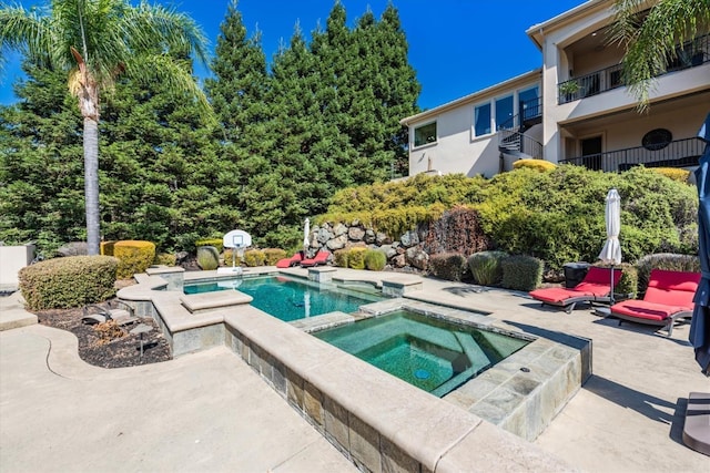 view of pool featuring an in ground hot tub and a patio