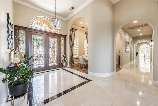 foyer with french doors and crown molding