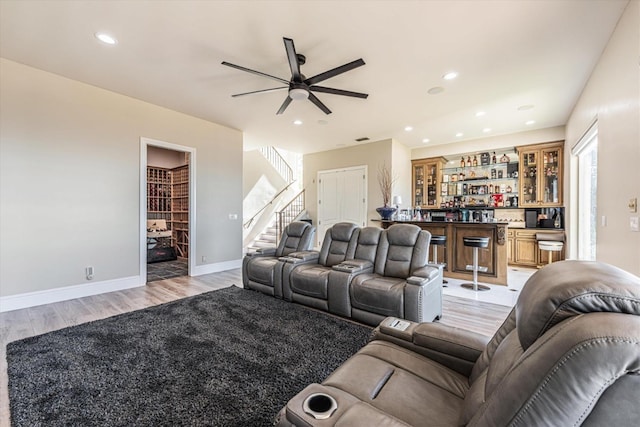 living room featuring ceiling fan, indoor bar, and light hardwood / wood-style floors