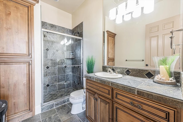 bathroom with toilet, a shower with shower door, and vanity