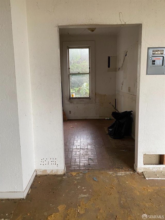 empty room with a textured wall and electric panel