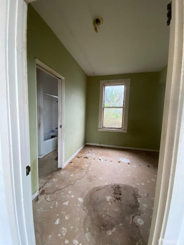 unfurnished bedroom featuring vaulted ceiling and baseboards