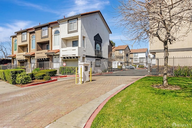 exterior space featuring a residential view, a gated entry, a gate, and curbs