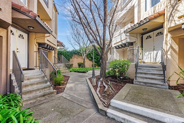 property entrance featuring a tiled roof and stucco siding