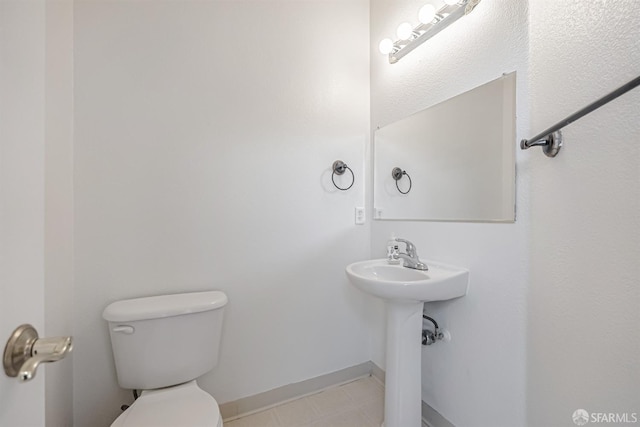 bathroom featuring baseboards and toilet