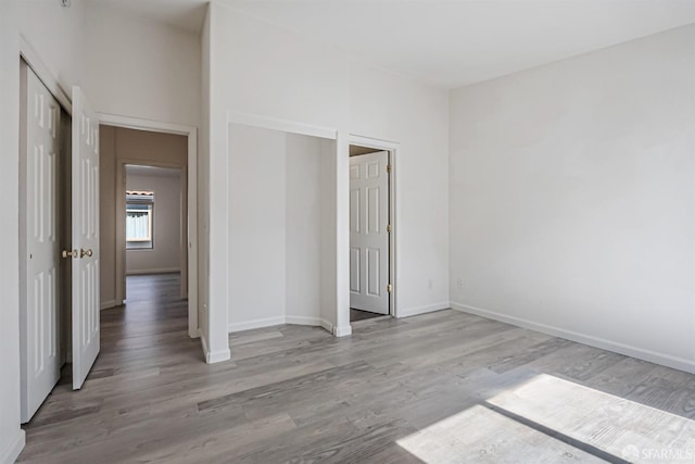 unfurnished bedroom with baseboards and wood finished floors