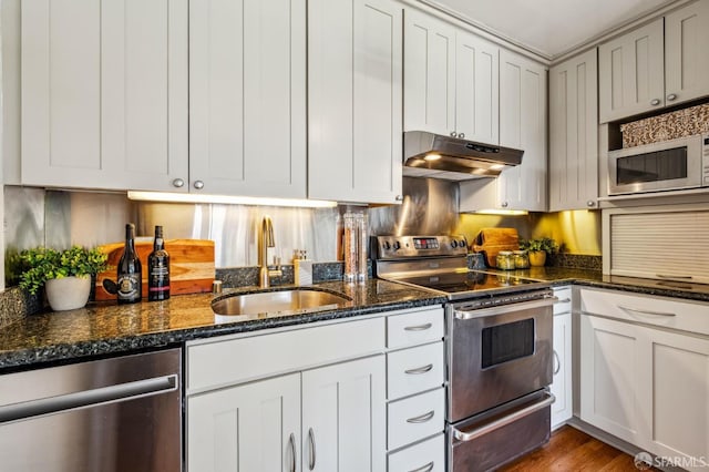 2171 Sacramento St Unit 4, San Francisco, CA 94109 - kitchen featuring appliances with stainless steel finishes, a sink, dark stone counters, wood finished floors, and under cabinet range hood