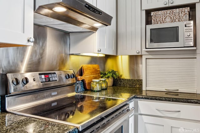 2171 Sacramento St Unit 4, San Francisco, CA 94109 - kitchen with under cabinet range hood, white cabinets, stainless steel electric stove, and built in microwave