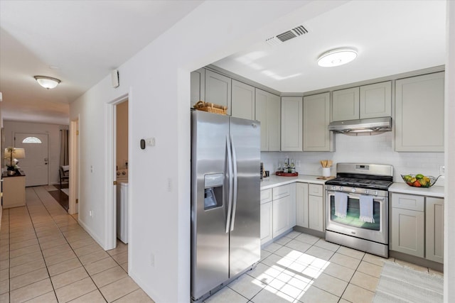 kitchen with tasteful backsplash, appliances with stainless steel finishes, light tile patterned flooring, and gray cabinets