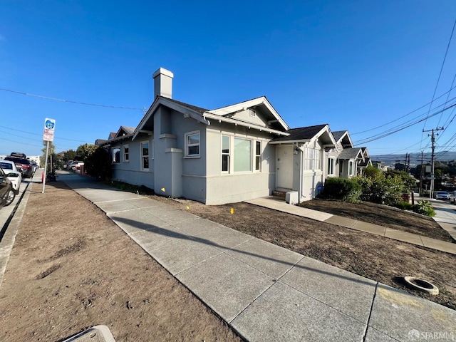 view of side of property featuring stucco siding and a chimney
