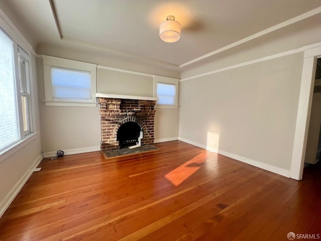 unfurnished living room featuring a fireplace, hardwood / wood-style flooring, and baseboards