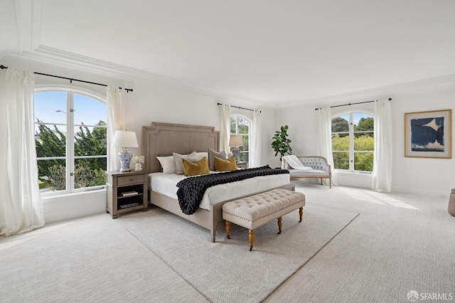 bedroom with ornamental molding and light carpet