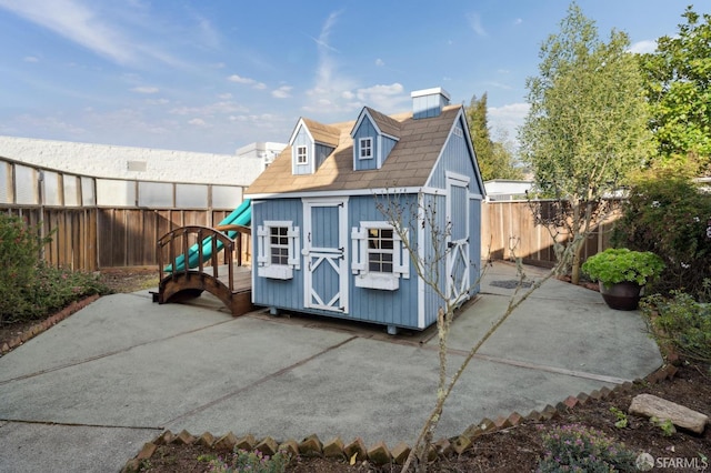 exterior space featuring an outbuilding, a patio area, a fenced backyard, and a storage unit