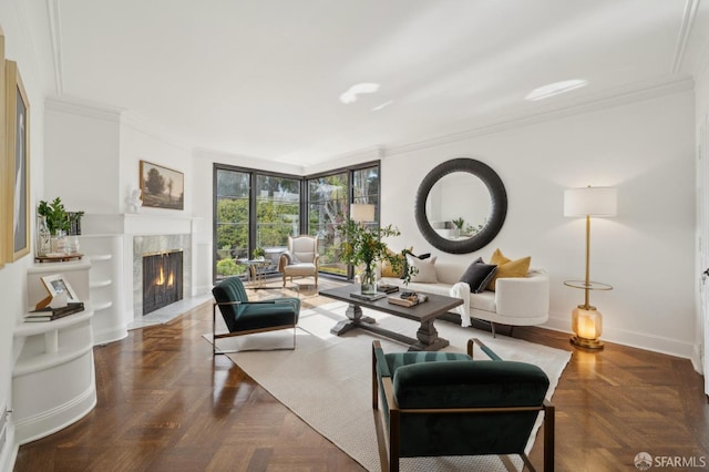 living area featuring baseboards, a high end fireplace, and crown molding