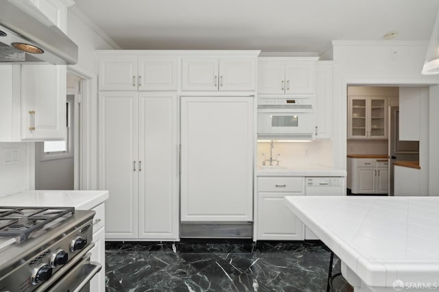 kitchen with white cabinets, white oven, tile counters, and under cabinet range hood