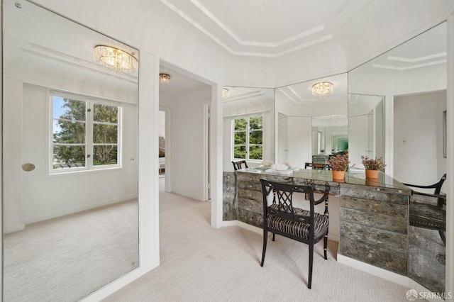 bathroom featuring an inviting chandelier, baseboards, and a raised ceiling