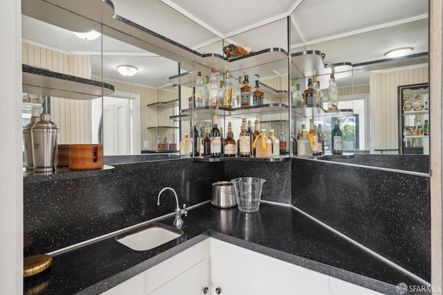 bar with crown molding, wet bar, and a sink