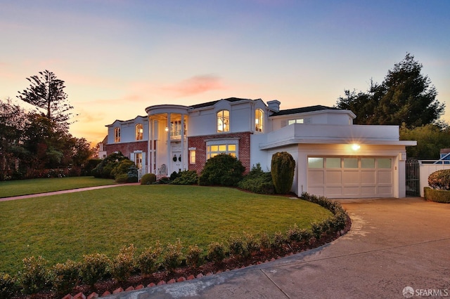 view of front of house with concrete driveway, brick siding, a front yard, and stucco siding