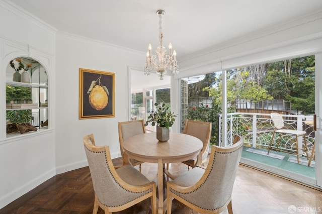 dining space with an inviting chandelier, baseboards, and crown molding