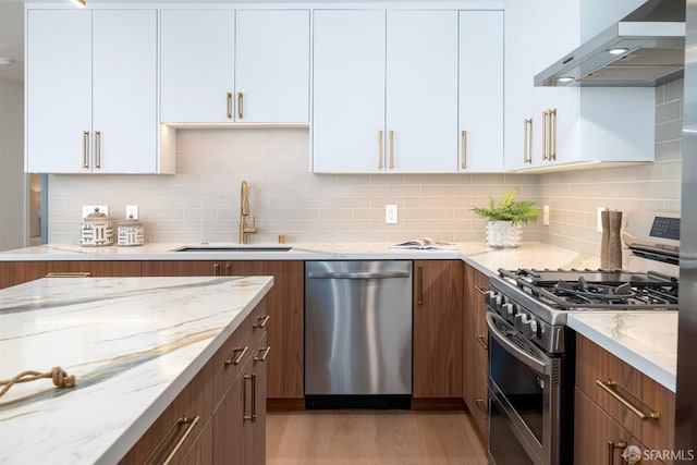 2277 33rd Ave, San Francisco, CA 94116 - kitchen featuring appliances with stainless steel finishes, wall chimney exhaust hood, light stone counters, white cabinetry, and decorative backsplash