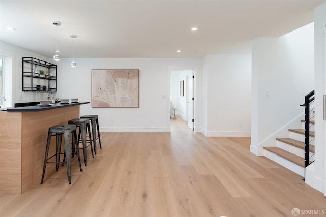 2277 33rd Ave, San Francisco, CA 94116 - kitchen with light wood-style flooring, a breakfast bar, recessed lighting, dark countertops, and pendant lighting