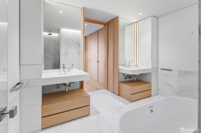 bathroom with sink, tile walls, and a bathtub