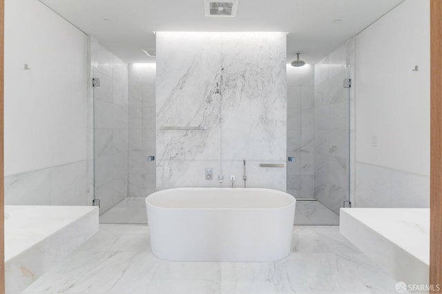 bathroom featuring tile walls and independent shower and bath