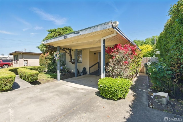 1146 Carlton Ave, Menlo Park, CA 94025 - view of front of house with stucco siding, concrete driveway, a carport, and fence