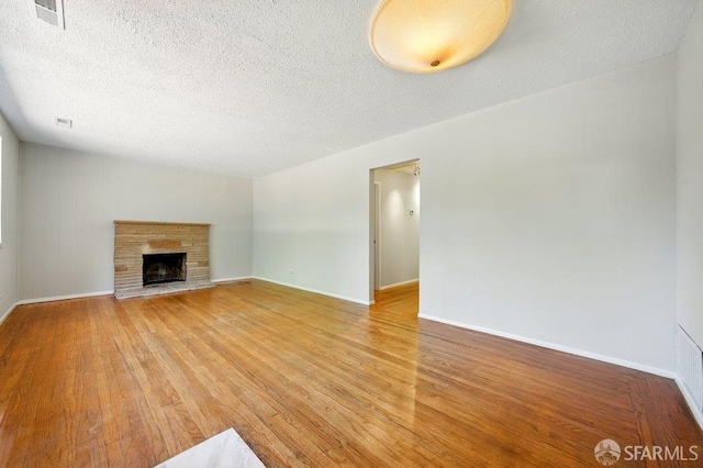 1835 Clayton Way, Concord, CA 94519 - unfurnished living room with light wood-style floors, a textured ceiling, baseboards, and a fireplace