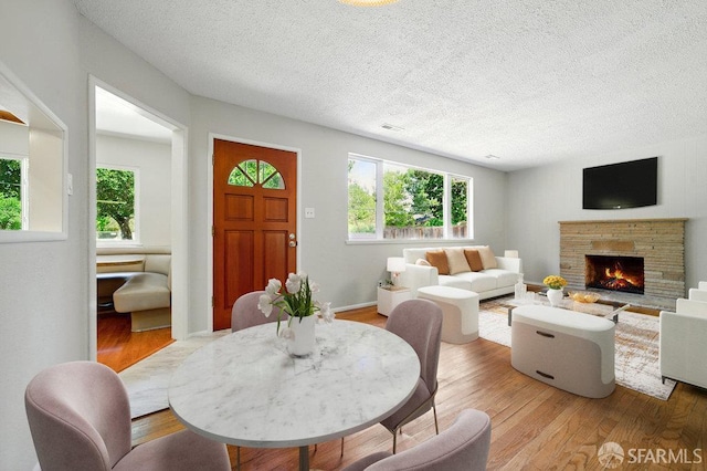 1835 Clayton Way, Concord, CA 94519 - dining space with wood finished floors, a textured ceiling, and a warm lit fireplace